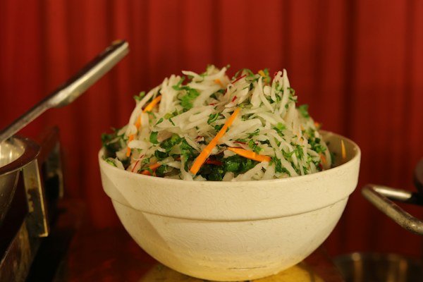 Ensalada de vegetales rallados y hierbas en un cuenco claro